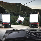 Coast EAL10R LED Lantern - Three camping lanterns on a table with a scenic background