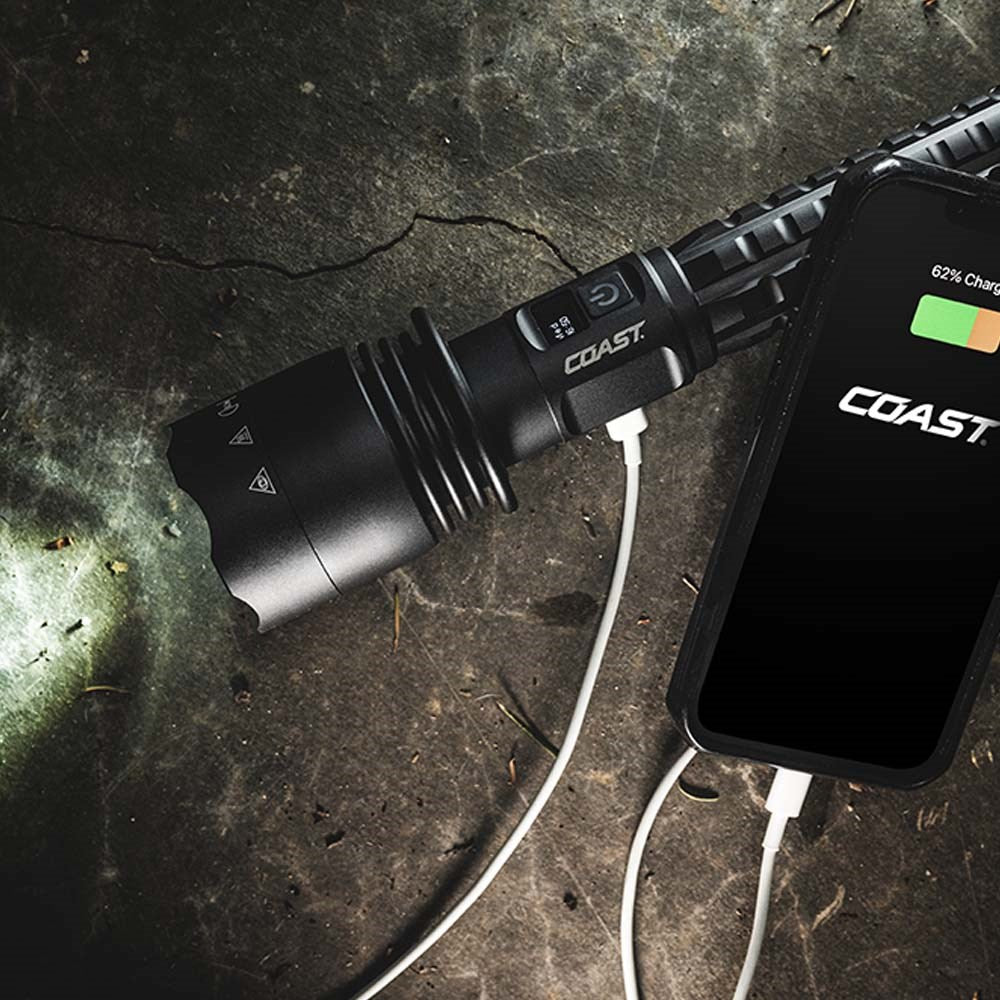 Coast XP40R LED Torch - Coast flashlights charging a phone on a textured surface