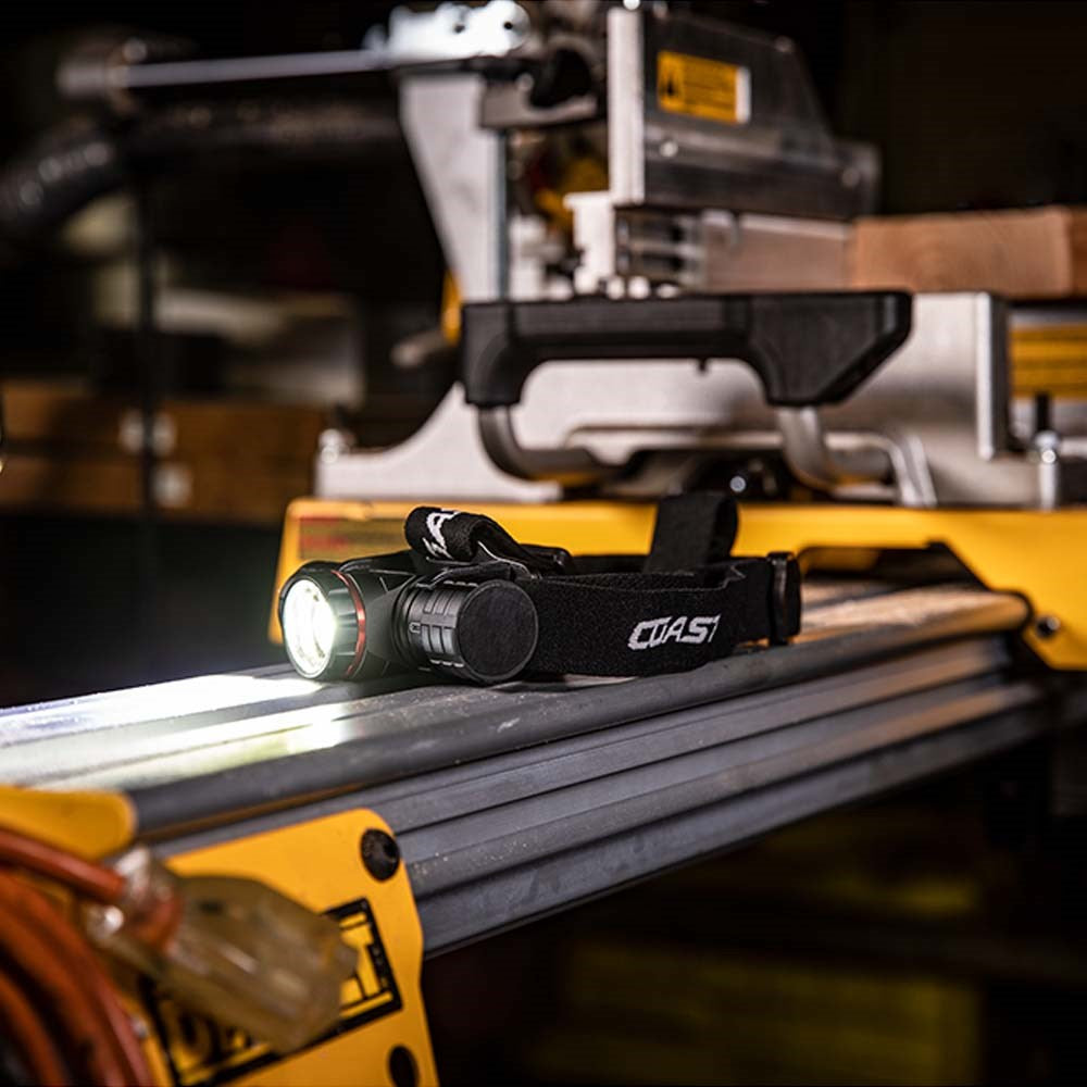 Coast XPH34R LED Headlight - Coast headlamp on a workbench with machinery in the background